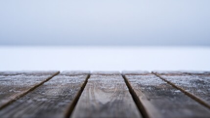 A single wooden board resting on the freezing ground, enveloped in the quiet beauty of winter.