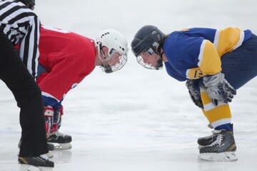 Naklejka premium Intense Face-Off Between Two Ice Hockey Players on Outdoor Rink