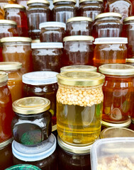 Honey store counter top full of types of honey jars in different colors with copy space for mockup
