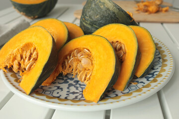 Pieces, slices of pumpkin on porcelain plate with blue pattern. Farm products and healthy eating....