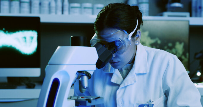 Scientist, woman or microscope analysis in lab for DNA sample, microbiology experiment or study. Blue light, genetic science or person with equipment for medical research, biotechnology or innovation