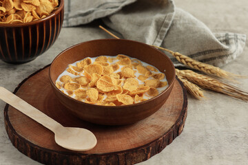Breakfast Cereal. Tasty Corn flakes with Milk in Brown Bowl