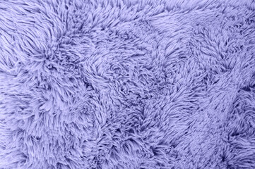 A close-up shot of a plush violet-colored textile displays a soft, fuzzy texture.