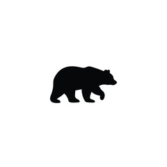 Fototapeta premium Black bear walking through grass with pine trees in the background
