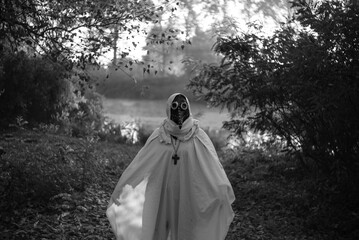 Foggy autumn landscape morning field with mysterious plague doctor