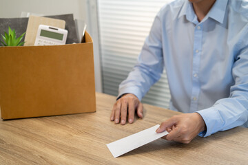 sending resignation letter to boss and Holding Stuff Resign Depress or carrying cardboard box by desk in office