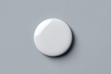 A blank, white, round badge on a gray surface