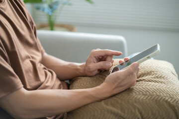 Relaxed young asian man using smart phone  spending time checking news social media