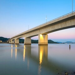 Serene bridge at dusk, calm waters reflect