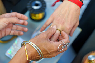 Skilled jeweler carefully positioning custom ring on client's finger during intimate moment at...
