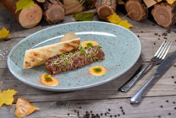 veal tartare with microgreens on a plate of bruschetta