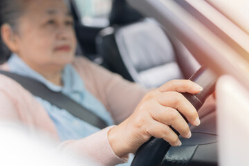 Senior woman hands, driving car, steering wheel. Retirement enjoying freedom and journey.