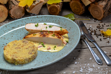 Couscous with chicken fillet in a blue plate on a wooden background