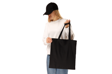 Young woman showcases a black tote bag in style, isolated on white, PNG