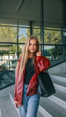 Woman in a red jacket carrying a black tote bag