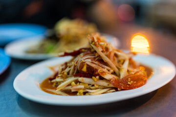 Thai spicy papaya salad in a white plate