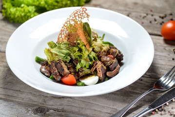 fresh salad with tomatoes and meat and eggplant in a white plate 
