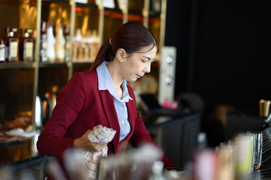 Asia woman cleaning a glass at bar