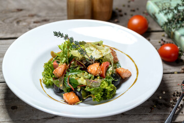fresh salad with tomatoes and salmon on a plate