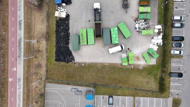 Aerial view of a waste disposal site with green dumpsters