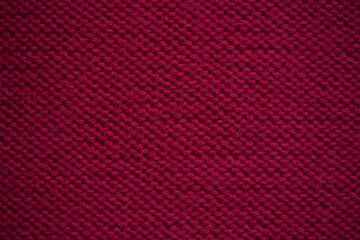 red Wool texture – red knitted fabric close-up Close-up texture of burgundy knitted wool fabric. Detailed symmetrical knit pattern. Soft textile background, suitable for fashion, crafts