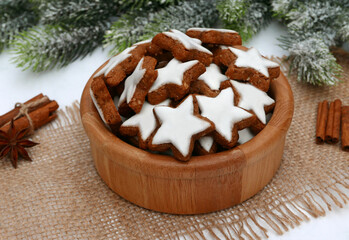 Zimtsterne  in einr Schüssel  mit Zimtstangen ,Anis und Tannenzweigen arrangiert. 