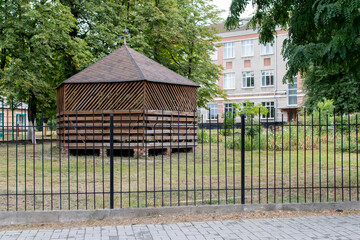 Wooden gazebo behind a metal fence