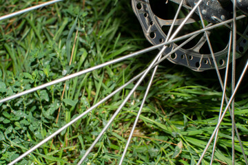 Close up of a bicycle wheel spokes against green grass