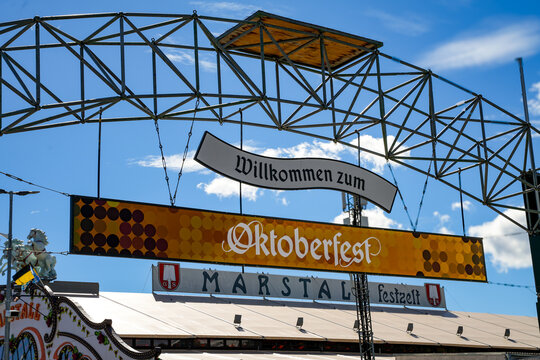 Official entrance to the Oktoberfest (Wiesn). Welcome sign "Welcome to the Oktoberfest" (in German). Roof of the Marstall Festzelt, one of the large festival tents
