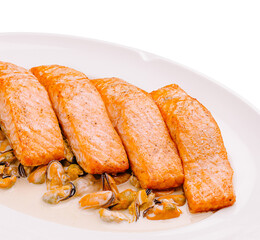 Salmon fillets served with fresh shellfish on a white plate at a restaurant