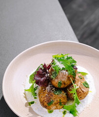 Gourmet baked potato dish served on a plate with fresh greens and herbs