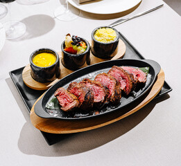 Delicious steak served on a sizzling platter with side dishes at restaurant