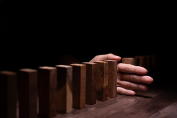 insurance with hands protect domino. hands stop dominoes falling in business crisis. business risk control and planning and strategies to run prevent insurance businesses.