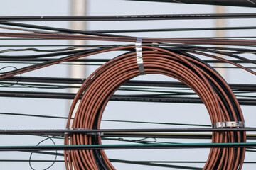 A steel cable car and a wire fence create a unique pattern on the glass facade of a modern urban...