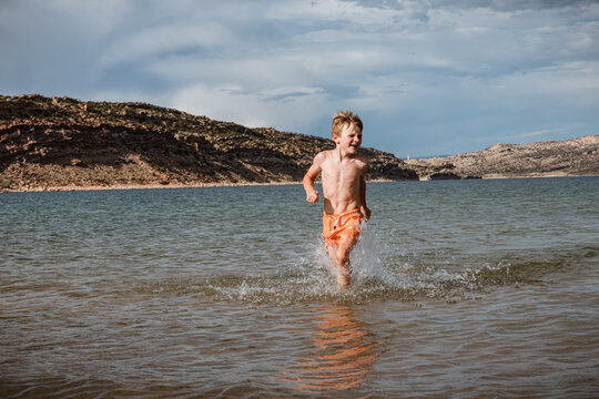 Child splashing playfully through water in Green River