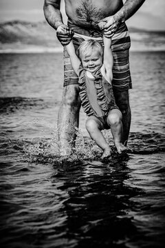 Dad playfully dipping baby daughter in river