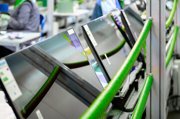 Fototapeta premium Televisions progressing along the conveyor belt in a busy manufacturing plant during a production cycle