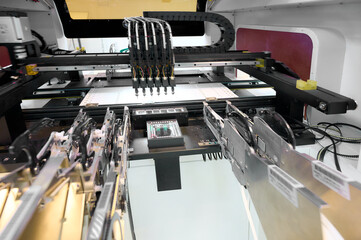 SMT placement machine in operation with multiple nozzles aligning components on a circuit board