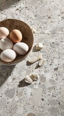 Eggs in a bowl, and broken bread, set on a patterned marble surface