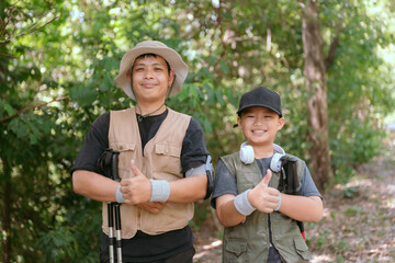 Fototapeta premium Two individuals smile and pose with thumbs up in a lush green forest, ready for a fun outdoor adventure