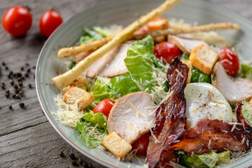 Caesar salad with bacon and grissini on a plate