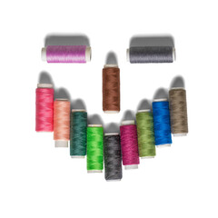 A stylized face with an evil smile made from spools of colorful thread. On a transparent background with a shadow.