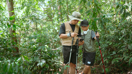 Father guides son through forest hike while exploring nature and learning about wildlife together