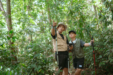 Men exploring nature in a tropical forest while guiding a young boy on an educational adventure