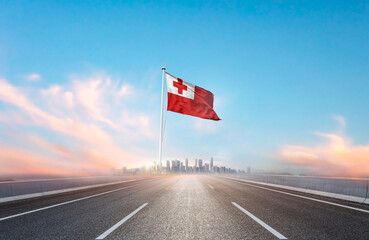 Tonga national flag with mast waving with beautiful skyline. A view from highway. Tonga flag for Republic Day and Independence Day.