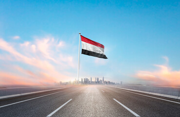 Yemen national flag with mast waving with beautiful skyline. A view from highway. Yemen flag for...