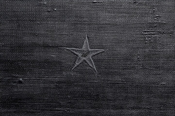 Distressed dark fabric texture with a faint star symbol in the center, minimal and symbolic background for Veterans Day