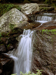 A closeup fast shutter photo of a mountain stream and waterfall in a park outside near the city of Taipei - the photo is taken right after sunset thus a bit dark