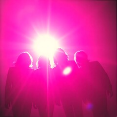 Four figures stand silhouetted against a bright pink light, creating a dramatic backlit effect. The use of color and composition evokes a sense of mystery and intrigue.
