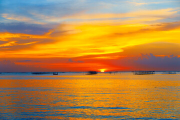 Obraz premium sunset in the sea. Beautiful colorful sky and cloud in twilight time background. Orange fluffy clouds and sun sunlight reflection in the blue sky.